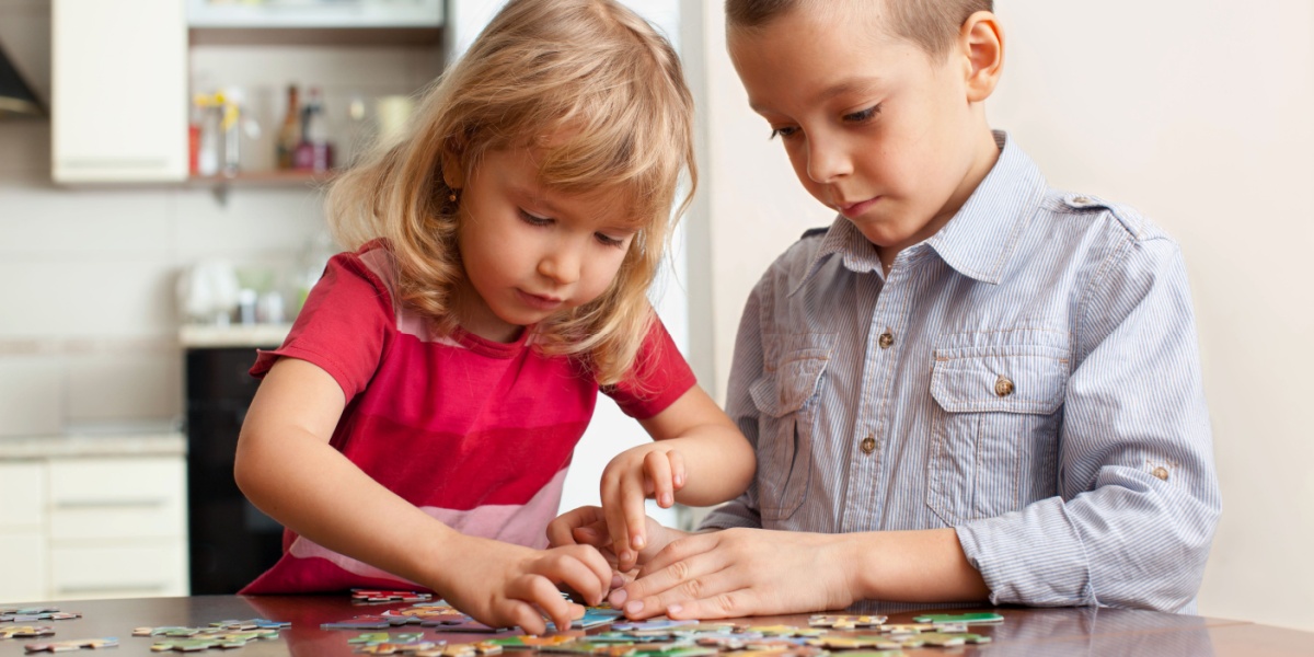 Tow children putting a puzzle together in this fun DIY indoor activity for kids.