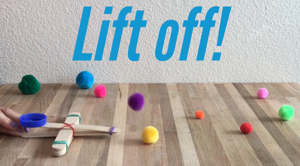 Launching a pom-pom using a homemade craft stick catapult