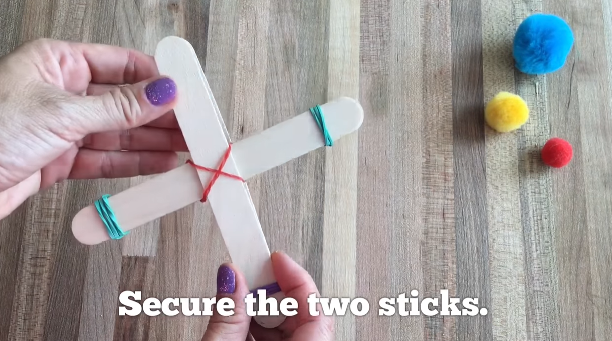 Adding a craft stick on top of the stack and securing it with a rubber band