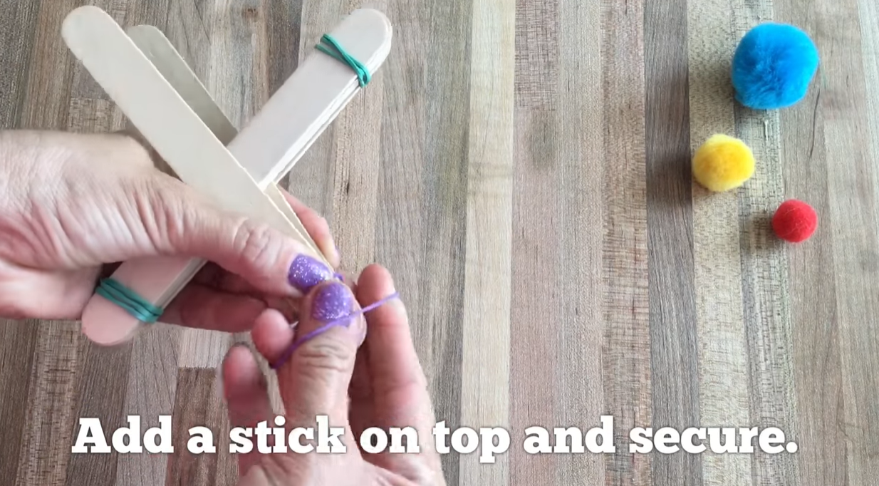 Sliding stacked craft sticks between two base sticks for a catapult