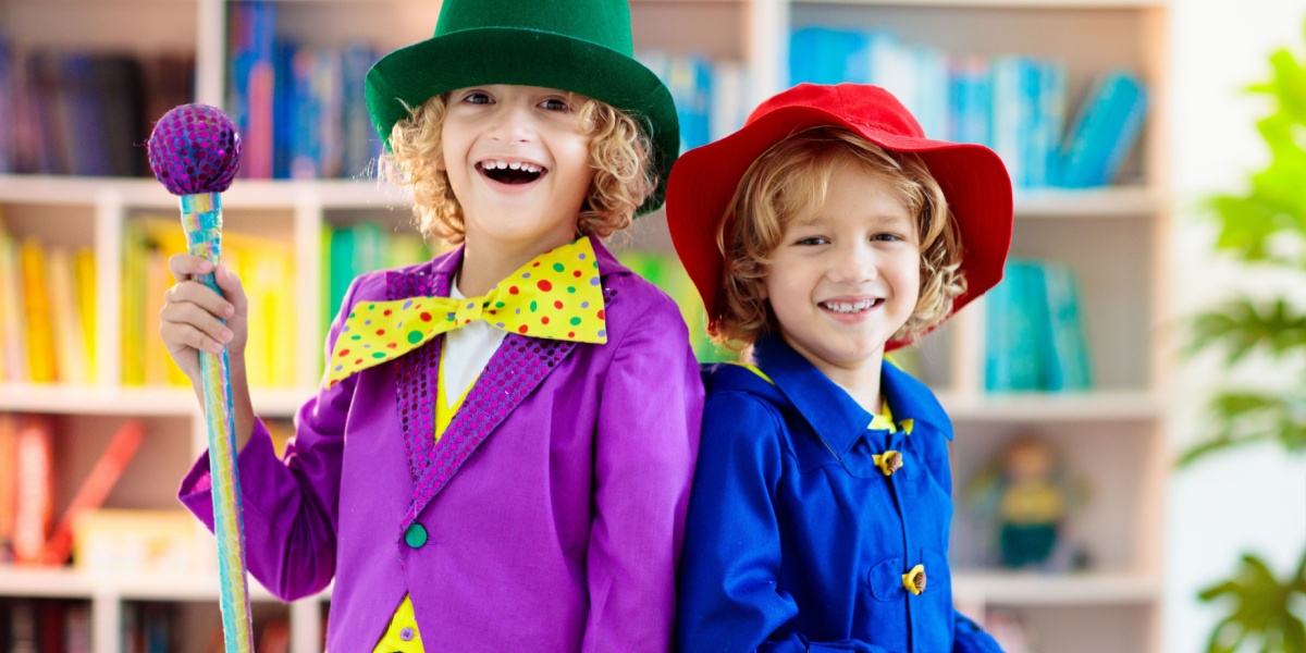 Two happy children dressing up in colorful jackets and hats.