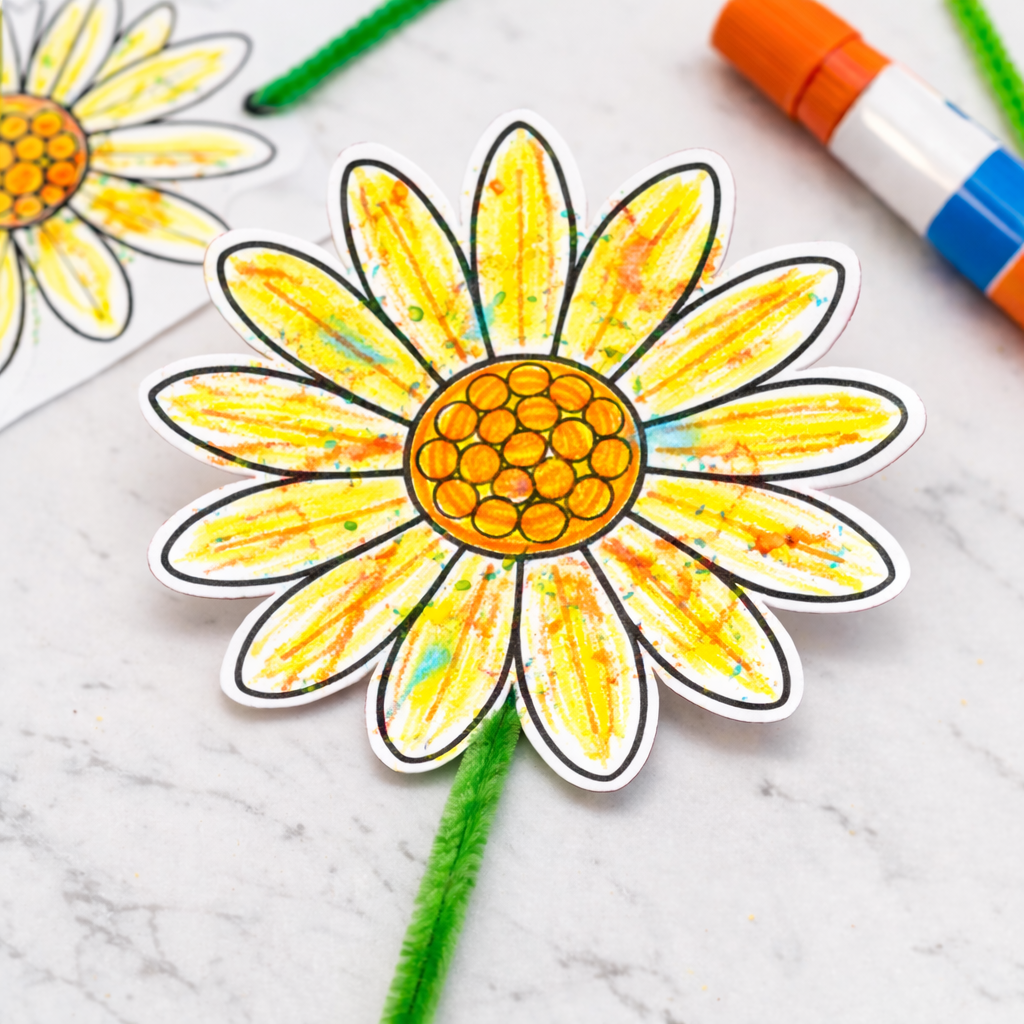 Hand-colored paper daisy with yellow center and crayon-textured petals attached to a green stem.