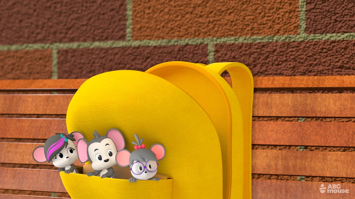 Three animated mouse characters peek out from a bright yellow backpack resting on a wooden bench against a brick wall.