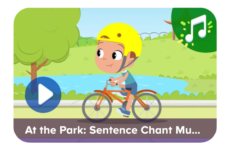Video thumbnail: cartoon child in a yellow helmet rides an orange bike in a park beside a pond; play button overlay and a music-note icon, with title 'At the Park: Sentence Chant Mu...'.