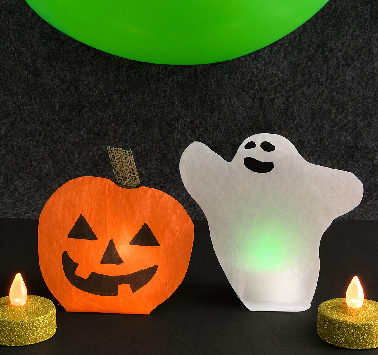 Glowing jack-o’-lantern and ghost Halloween decorations with battery-operated lights.